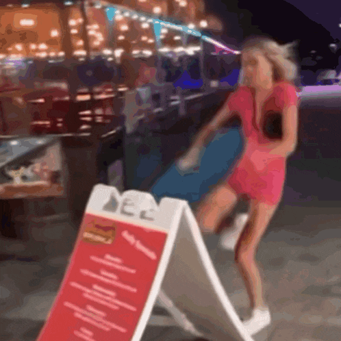 a woman in a pink dress is standing next to a sign that says ' dec ' on it