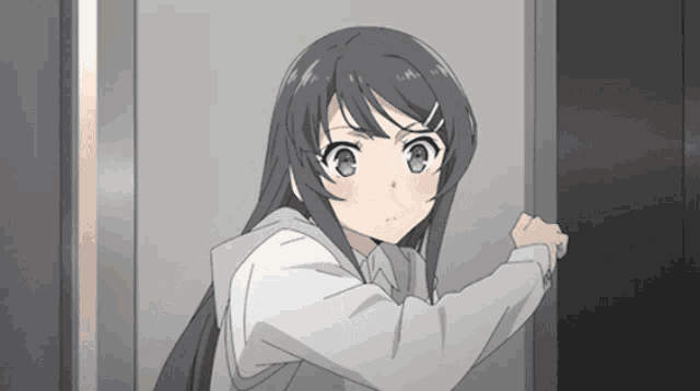 a girl with long hair is standing in a doorway looking at the camera
