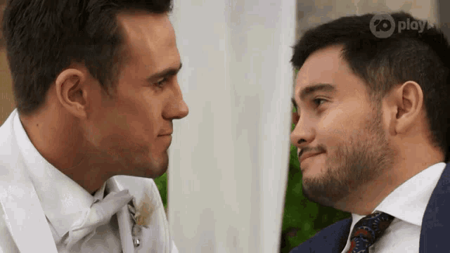 two men are looking at each other with a 20 play logo on the bottom right