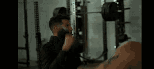 a man in a black jacket is holding a camera in a dark room