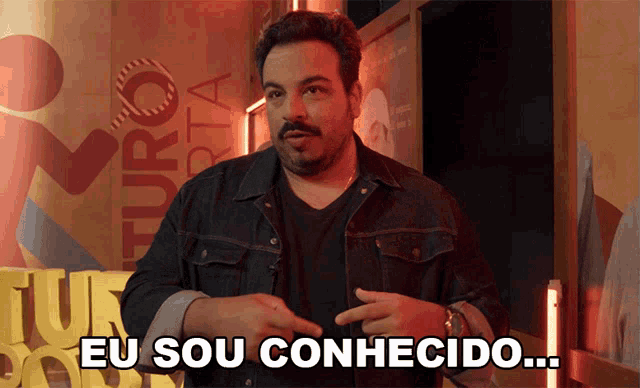 a man says eu sou conhecido in front of a sign
