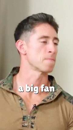 a man in a camouflage shirt with the words a big fan above his neck