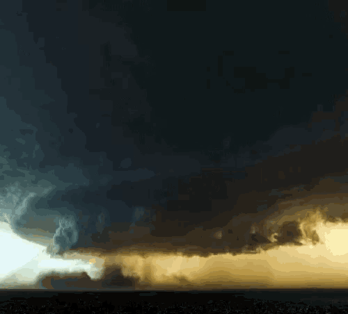 a dark cloudy sky with a yellow glow in the middle