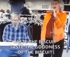 a woman is singing into a microphone while a man sits at a keyboard in a store .