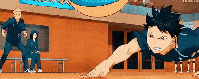 a man is doing push ups on a volleyball court while a group of people are watching .