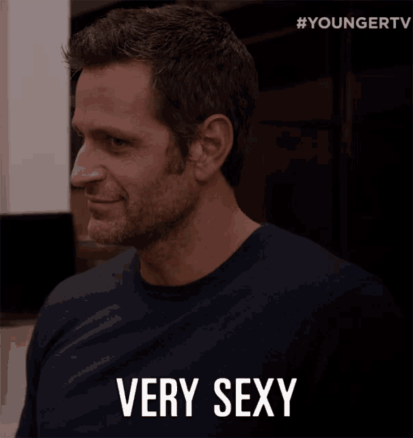 a man in a black shirt says very sexy in white letters