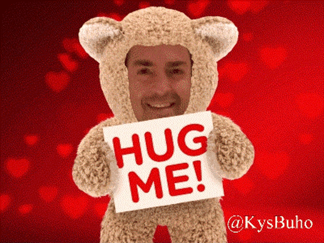 a man in a teddy bear costume holds a sign that says hug me