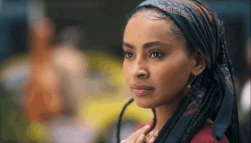 a woman wearing a scarf around her head is looking at the camera .
