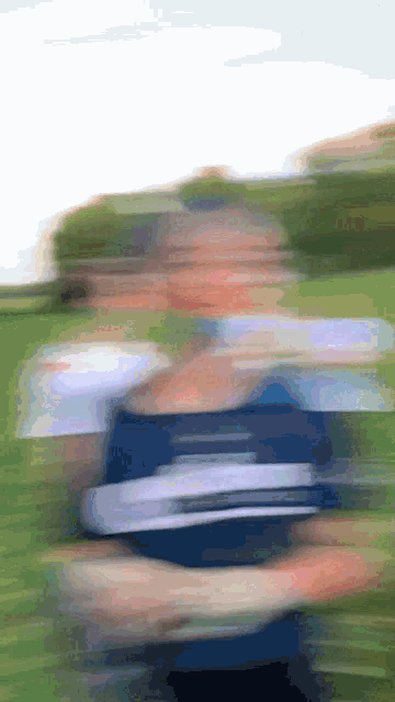 a blurry picture of a person holding a frisbee in the grass