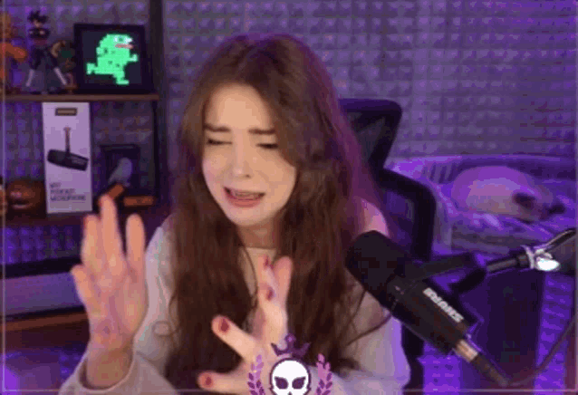 a woman is sitting in front of a microphone in a room with purple lights .