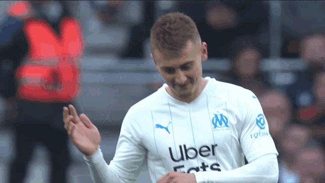 a soccer player wearing a white jersey that says uber eats on it