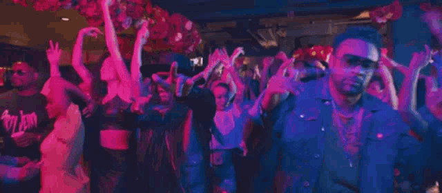 a large group of people are dancing in a nightclub .