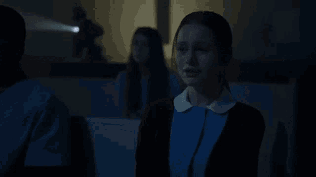 a woman is crying in a dark room in front of a projector screen .