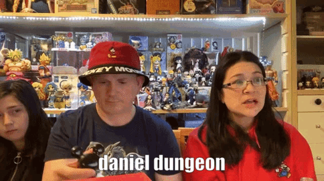 a man wearing a mickey mouse hat says daniel dungeon in front of a group of people