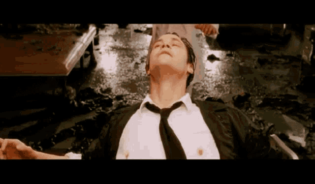 a man in a white shirt and tie is laying on the floor
