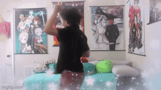 a person is standing on a bed in a room with posters on the walls .