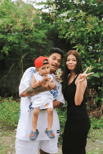 a man in a white shirt with the word supreme on it is holding a baby