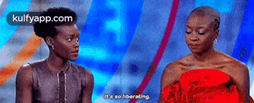 two women are sitting next to each other on a stage and one of them is saying `` it 's so liberating . ''