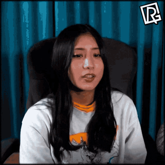a woman sitting in a chair with the letter r on the bottom right