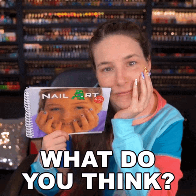 a woman is holding a book that says nail art on it