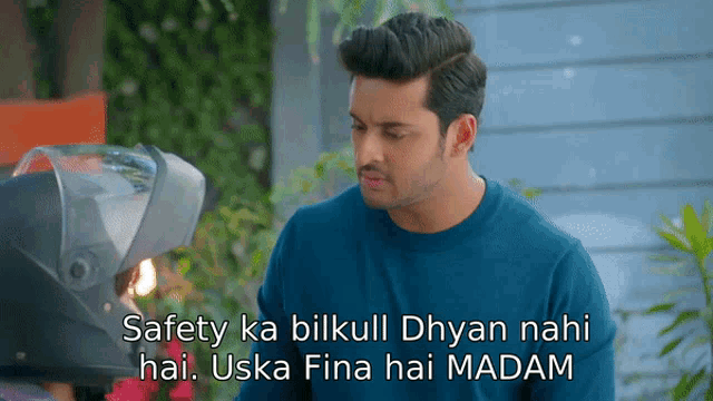 a man standing next to a helmet that says safety ka bilkull dhyan nahi hai .. uska fina hai madam