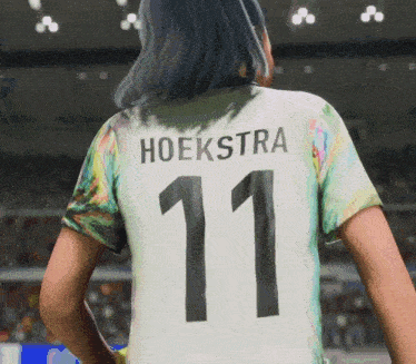 a woman wearing a soccer jersey that says hoekstra 11