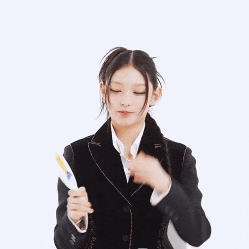 a woman in a black suit is covering her face with her hands