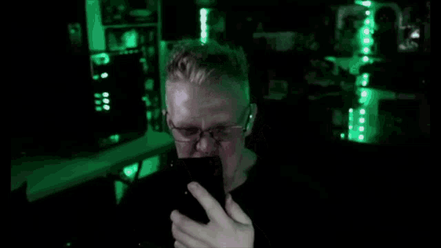 a man is taking a picture of himself with a cell phone in a dark room .