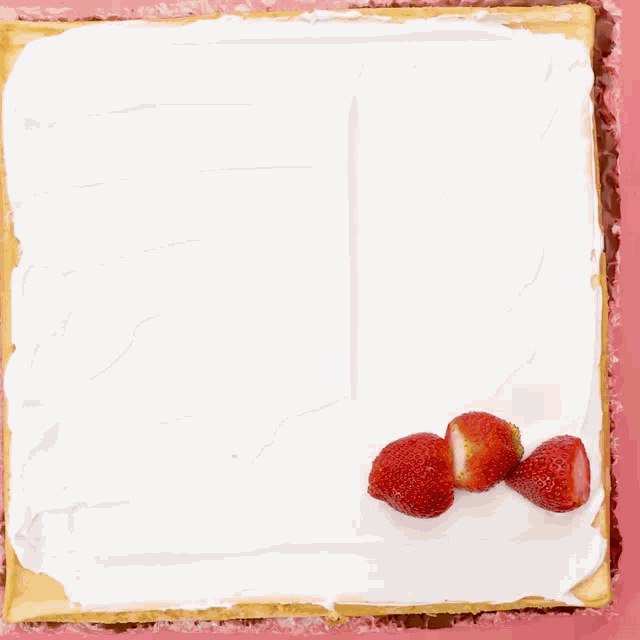 strawberries are lined up on top of a white frosting