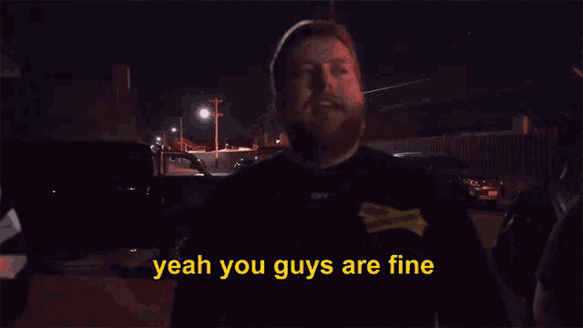 a man in a black shirt with a yellow sticker that says you do anything