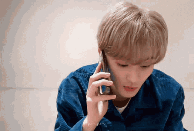 a man in a blue jacket is talking on a phone
