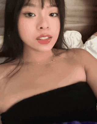 a woman wearing a black strapless top and a gold necklace