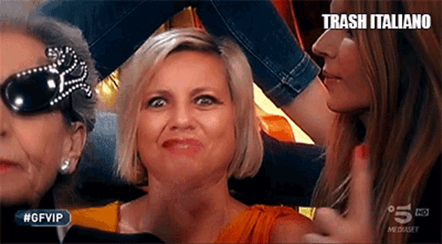 a woman is making a funny face in front of a sign that says trash italiano .