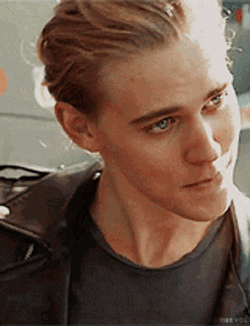 a close up of a man 's face with a black jacket on