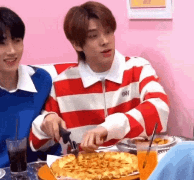 a man is cutting a pizza with a knife .