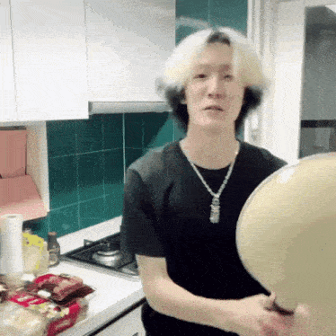 a man in a black shirt is cooking in a kitchen