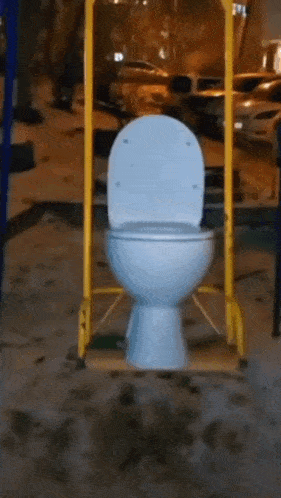 a toilet is hanging from a yellow pole in a playground .