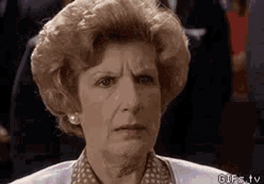 an elderly woman is making a funny face while sitting in a chair .