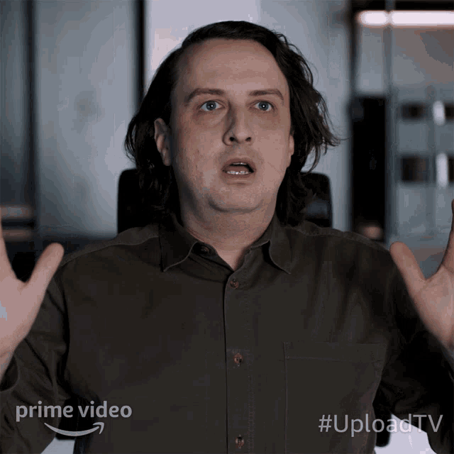 a man is making a funny face in front of a sign that says " prime video "