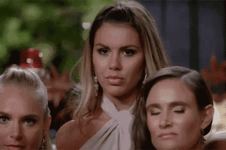 three women are standing next to each other and one of them is making a face .