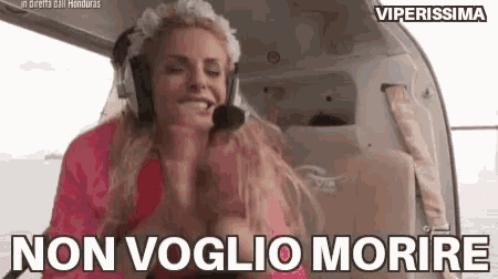 a woman wearing headphones is sitting in a helicopter with the words non voglio morire written below her .