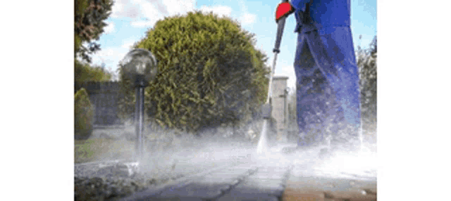 a person is using a high pressure washer to clean a sidewalk
