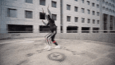 a person is dancing in front of a building that has the word black written on the ground