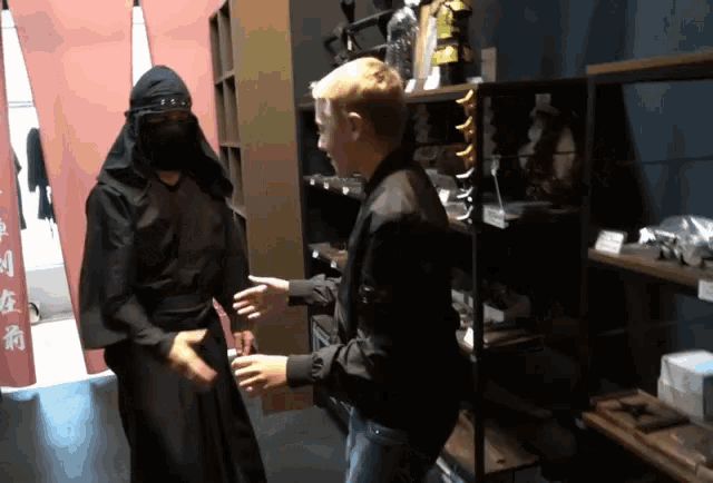 a man in a black jacket is shaking hands with a man in a black robe