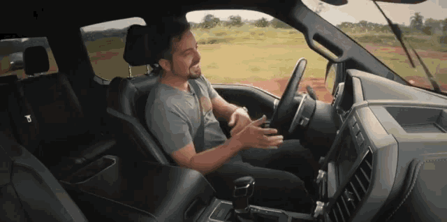 a man is sitting in the driver 's seat of a truck with the letter p on the dashboard