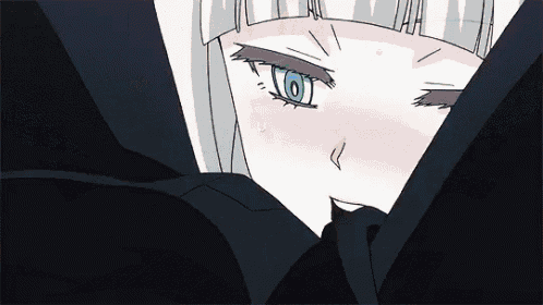a close up of a girl 's face with blue eyes and a black shirt .