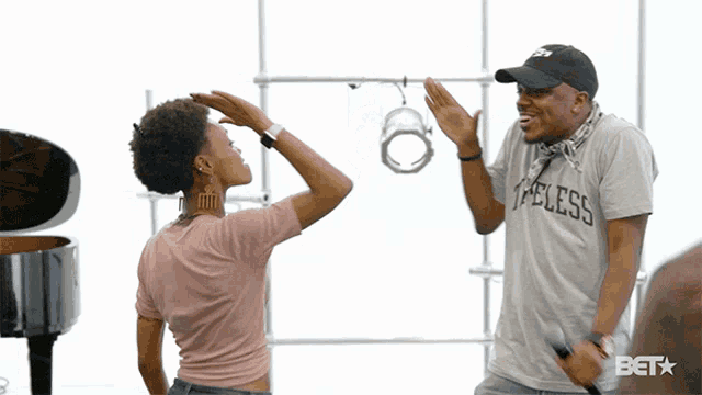 a man wearing a shirt that says " i feelss " high fives another man