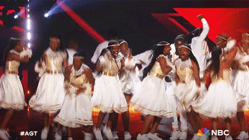 a group of people are dancing on a stage with a nbc logo on the bottom