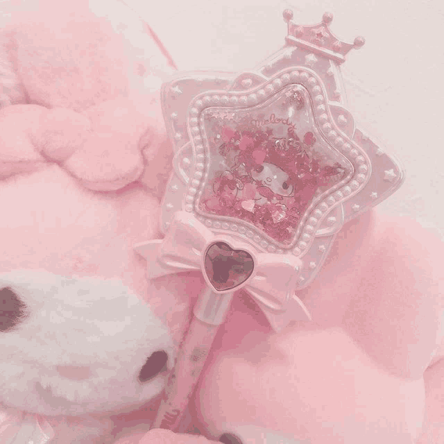 a stuffed animal with a pen that says ' hello kitty ' on it