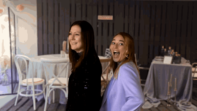 two women are standing next to each other in front of a sign that says ' closed '